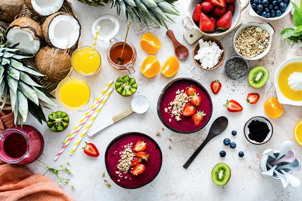 preparing acai bowl in flat lay style with tropical fruits and grains - Правила приготовления смузи-боулов