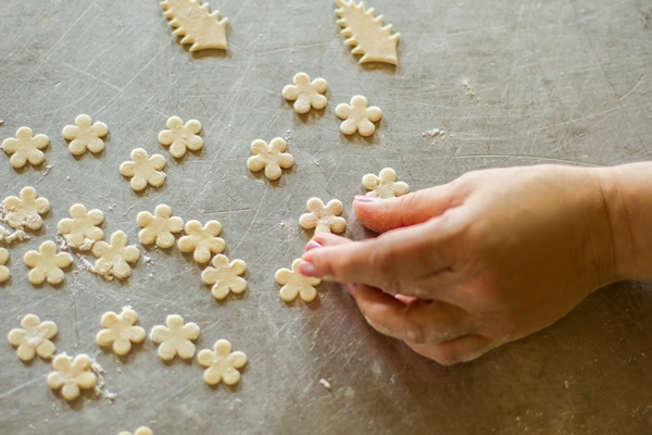 hand touches flower from dough little pieces of raw pastry baker makes decoration for food recipe and artwork - Свадебный каравай