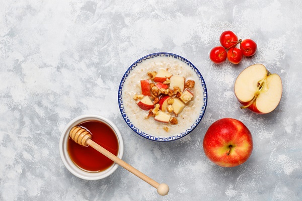 Корневище кипрея (иван-чая) oatmeal porridge in a bowl with honey and red apple slices top view - Корневище кипрея (иван-чая)