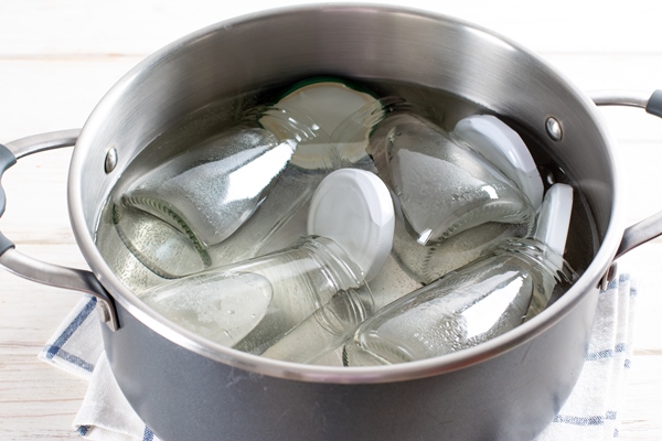 sterilizing glass jars in a steel pan steaming bubbling wather 1 - Варенье "Пятиминутка" из клубники