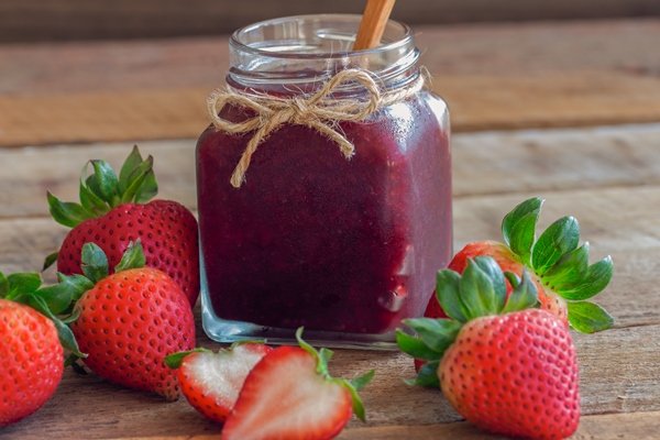 homemade delicious strawberry jam in bottle put on rustic wood table with copy space - Клубника, протёртая с сахаром