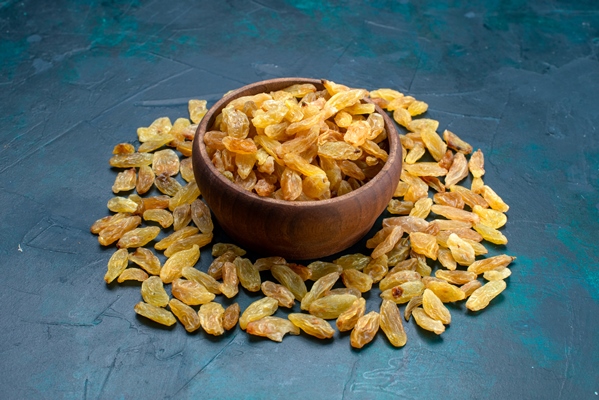 front view dried raisins inside and outside brown pot on the blue background - Традиционные напитки сочельника: узвар, плодово-ягодный кисель