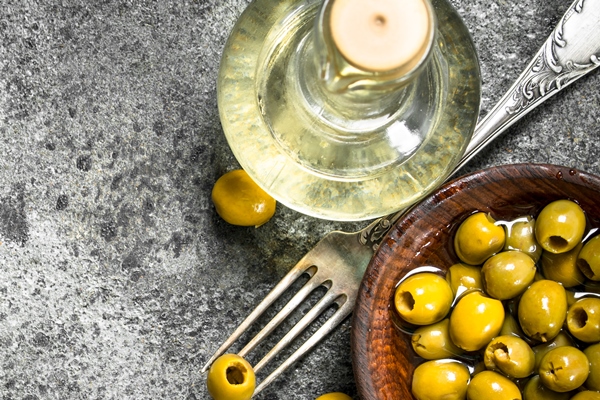 Оливковое масло pickled olives with olive oil on a rustic table - Оливковое масло