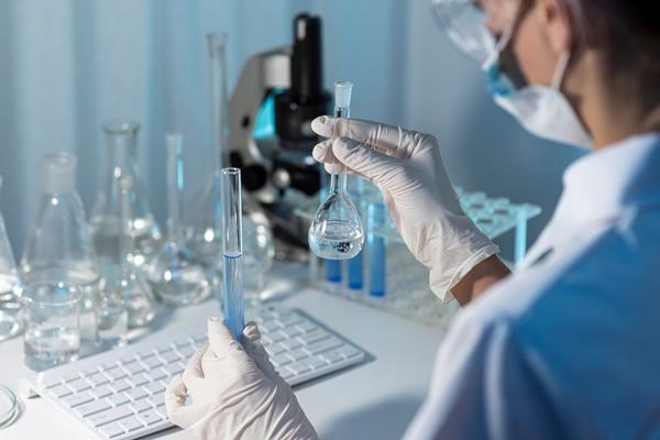 close up researcher holding glassware - Пищевые добавки: вред и польза