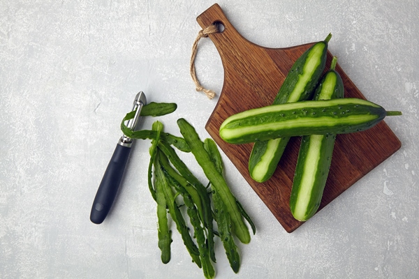Хозяйке на заметку: виды кухонных ножей peeled cucumbers on a wooden cutting board with a vegetable peeler and peels - Хозяйке на заметку: виды кухонных ножей