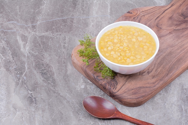 pea beans soup on wooden platter with herbs around - Горошница (школьное питание)