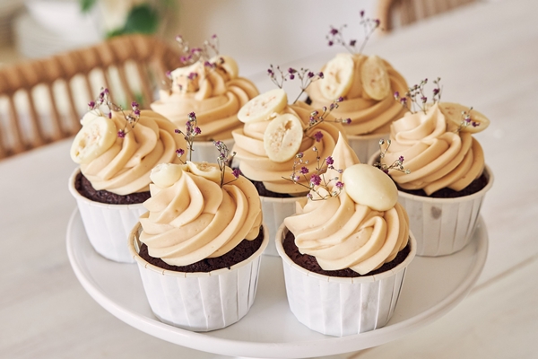 Капкейк selective focus shot of delicious chocolate cupcakes with white cream topping - width=