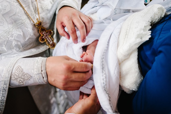 the sacrament of baptism newborn baby during christening and chrismation infant baby baptism in holy water - Кулинарные традиции празднования именин