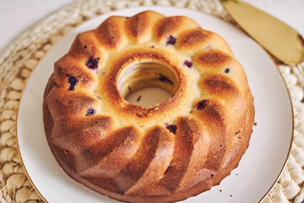 vertical shot of a ring cake on a white table - width=