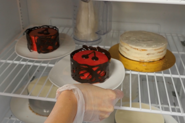 Фраппировать woman puts sweet cake in the refrigerator cake in the fridge - width=
