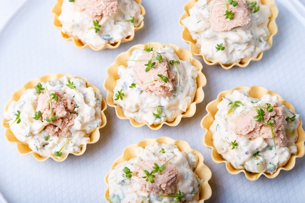 tartlets stuffed with codfish liver codfish caviar cucumber microgreens traditional cold portioned appetizer pastry basket close up top view - Тарталетки с печенью и икрой трески