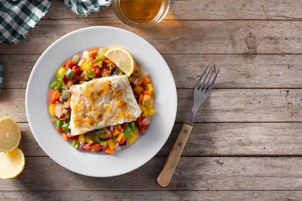 Рыба по-афонски grilled cod with vegetables plate wooden table - Рыба по-афонски