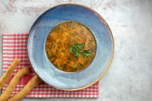top view hot vegetable soup with greens inside plate white space - Щи "ленивые" с копчёностями