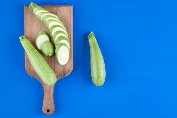 fresh green zucchini slices placed wooden board - Маринованные кабачки с гвоздикой и корицей