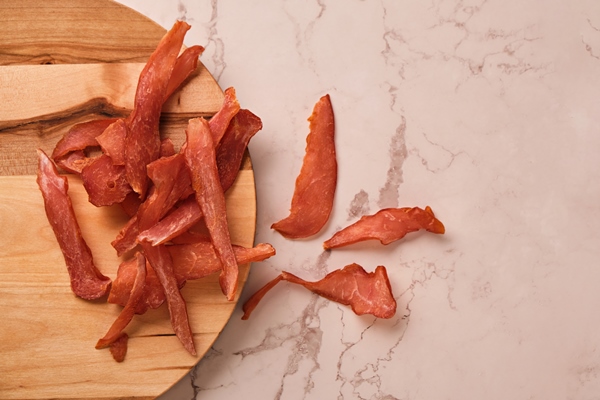Как насушить мясо в домашних условиях jerky chicken meat chips on a light marble background - Как насушить мясо в домашних условиях