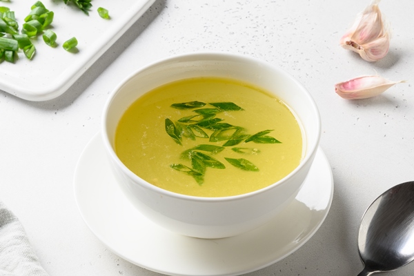 Оттяжка chicken broth with greens white bowl white table copy space - Оттяжка