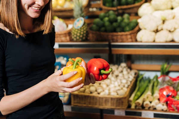 close up smiley woman holding bell peppers - Товарное соседство продуктов