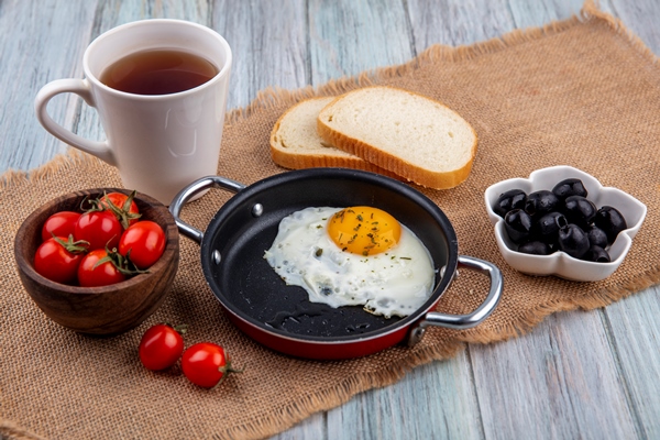 Яйца кокот front view fried egg pan with bowl tomato tea with bread slices bowl olive sackcloth wooden surface - Яйца кокот