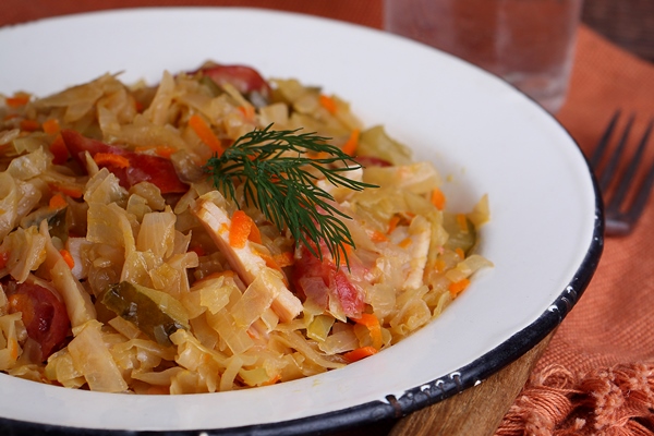 Бигос sauerkraut with sausage onions carrots white plate - Бигос