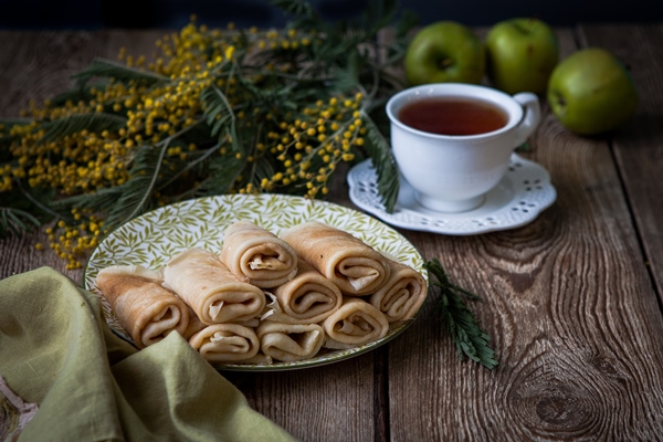 Блинчики side view pancakes with cup tea mimosa flowers apple wooden table - Блинчики