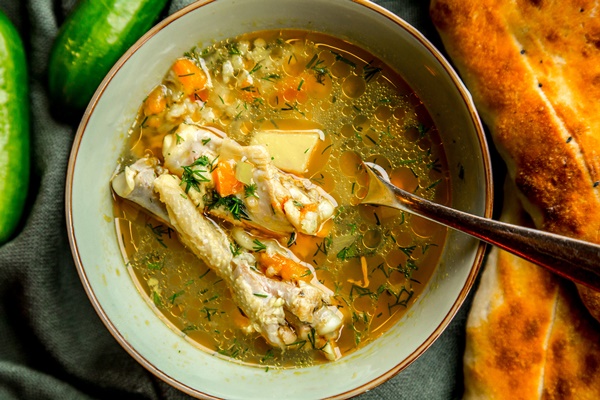 top view chicken soup served with herbs cucumbers bread - Рассольник домашний