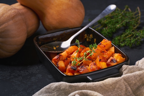 baked butternut squash cubes with thyme black stone table - Тыква в маринаде