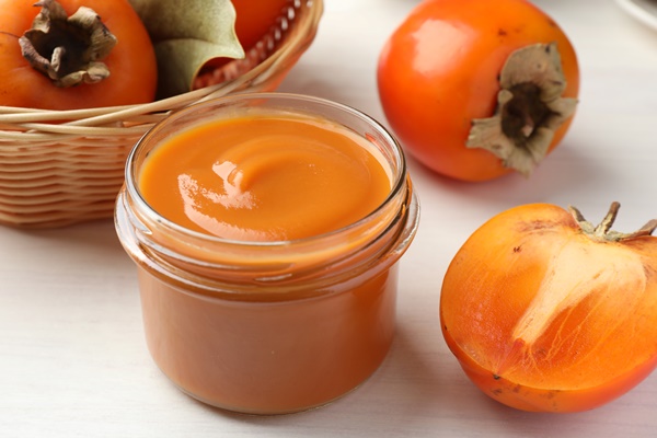 delicious persimmon jam glass jar fresh fruits white wooden table closeup - Варенье из хурмы