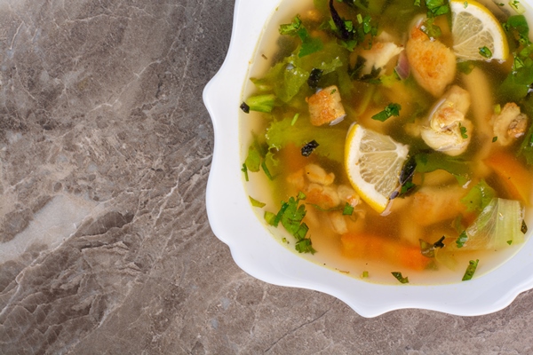 delicious soup with greens slices lemon white plate - Калья из форели
