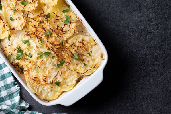 potato gratin baked with cream cheese black slate background - Брюква, фаршированная сухарями (старинный рецепт)