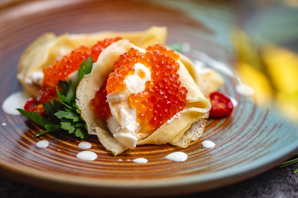 close up crepes with red caviar cream garnished with parsley - Начинка для блинов с икрой, йогуртом и красным луком