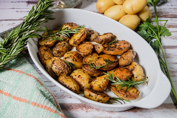 Картофель запечённый "Особый" oval white dish with delicious roasted potatoes with fresh natural herbs cut view - Картофель запечённый "Особый"