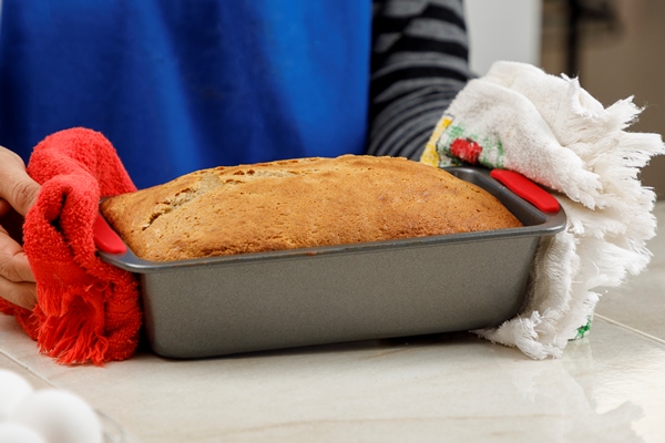 woman taking pancake out oven with her hands home baking concept - Картофельный сладкий пирог