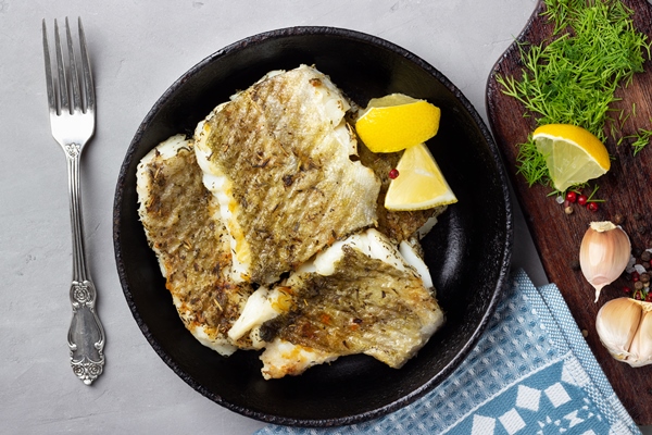fried cod fish fillet with spice cast iron pan top view - Секреты жарения рыбы