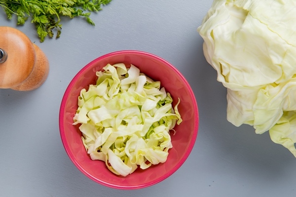 top view cabbage slices bowl with whole one coriander salt blue background - Салат из белокочанной капусты с лимоном