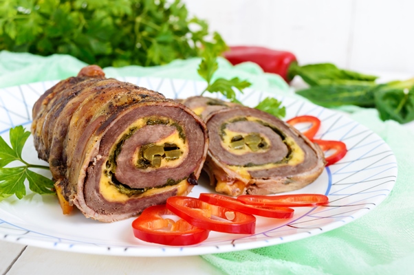 delicious meat roll with spinach cheese pickled cucumber plate white wooden background - Мясные рулетики