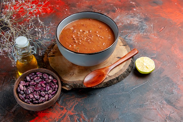 horizontal view tomato soup blue bowl tray beans oil bottle mixed color table - Фасолевый суп с овощами и орехами