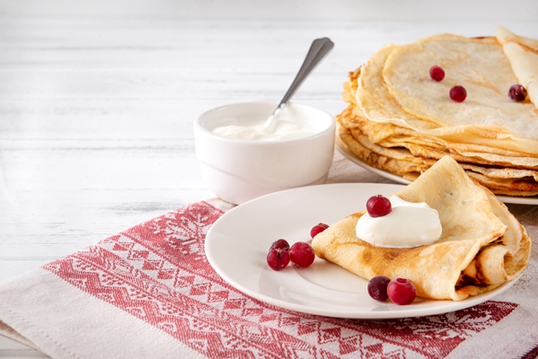 Боярские блинцы на сливках russian pancakes with berries sour cream plate towel with red pattern white surface - Боярские блинцы на сливках