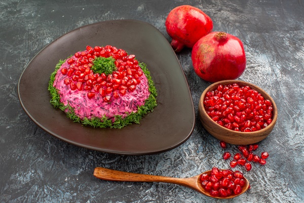 Постный салат "Гранатовый браслет" side close up view pomegranates appetizing dish bowl pomegranate seeds spoon - Постный салат "Гранатовый браслет"