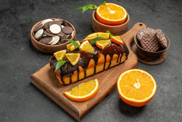 Манник с апельсинами и маком в шоколадной глазури vid sboku vkusnyh tortov narezannyh apel sinov s pecen em na razdelocnoi doske na temnom stole - Манник с апельсинами и маком в шоколадной глазури