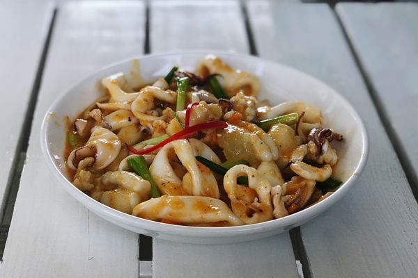 vysokougol nyi vid salata na tarelke na stole - Кальмары в соусе тэрияки