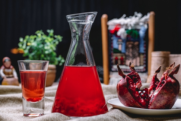 sok granata v kuvsine s semenami vnutri fruktovogo vystrela vid sboku - Гранатовый сироп для десертов