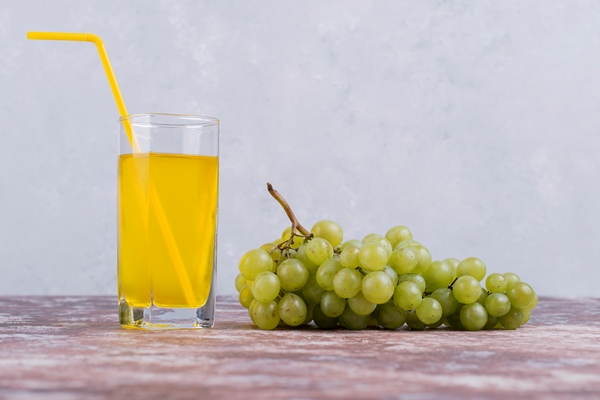 Виноградный нектар grozd zelenogo vinograda so stakanom soka na sinei stene - Виноградный нектар