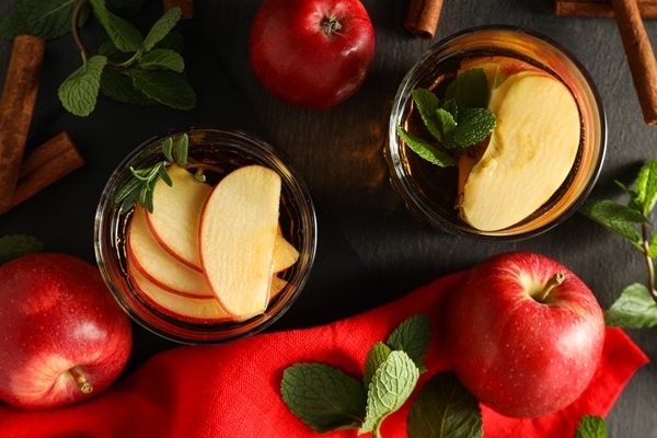 ocki s list ami matnogo ablocnogo sidra i krasnymi ablokami na temnom derevannom fone - Яблоки в сиропе