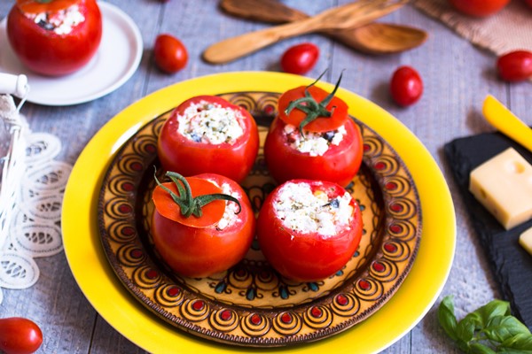 farsirovannye pomidory s syrom i raznymi ovosami na derevannom stole - Помидоры, фаршированные брынзой