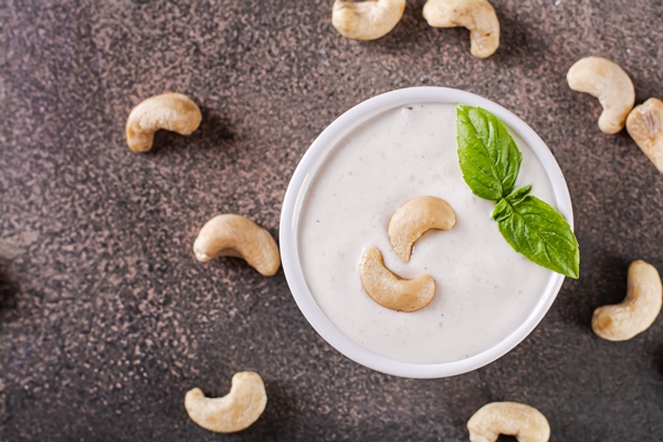 Постный майонез из кешью krupnyi plan veganskogo sousa kes u v miske s bazilikom na stole dla rastitel noi diety vid sverhu - Постный майонез из кешью