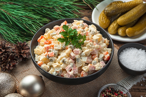 Постный салат "Оливье" с соевой колбасой salat oliv e v cernoi miske na temnom fone s elocnymi ukraseniami - Постный салат "Оливье" с соевой колбасой
