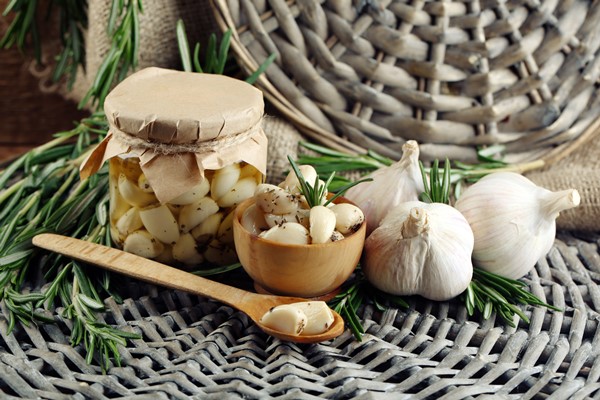 Томлёный чеснок конфи canned garlic glass jar rosemary branches wicker mat background - Томлёный чеснок конфи