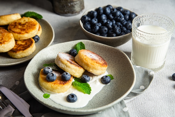 plate food with blueberries glass milk - Творожники с картофелем