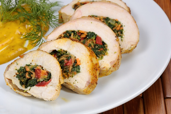 slices chicken breast stuffed with spinach carrot pepper tomato plate - Мясной рулет с сыром