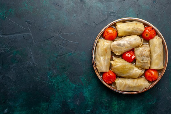 Постная долма с бобовой начинкой по-армянски top view delicious meat meal rolled inside cabbage with tomatoes dark blue desk meat food dinner calorie vegetable cooking - Постная долма с бобовой начинкой по-армянски